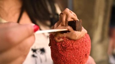 Turist kadın geleneksel Trdelnik ya da trdlo Çek tatlısını deniyor. Prag caddesinde Trdlo 'yu tutan kadın. Sokak yemeği. Trdelnik şekerli ve tarçınlı geleneksel tatlı bir pasta. 4K.