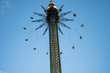 Dev feribot çarkı bir lunaparkta insanlarla hareket ediyor. Eğlence için güneşli bir gün. Kopyalama alanı.