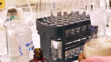 Biyoteknoloji araştırma ve uyuşturucu geliştirme laboratuvarında temiz NMR tüplerinde reaksiyon karışımından örnekler hazırlayan bir araştırmacı bilim adamı