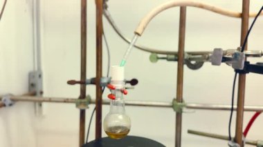 Küçük bir cam şişede kimyasal bileşik sentezi ve kimyasal reaksiyon için yuvarlak bir şişe. 4K 