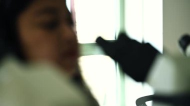 Mikroskop altında örneklere bakan kadın bir bilim adamının gözlerini kapat. Modern Laboratuvarda Teknolojik Ekipmanlarla çalışan 4K Mikrobiyolog. Biyokimya, ilaç..