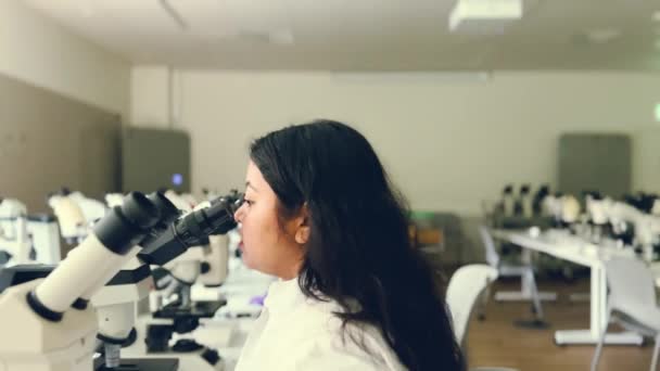 Крупный План Женских Исследовательских Глаз Изучающих Образцы Микроскопом Микробиолог Работающий — стоковое видео