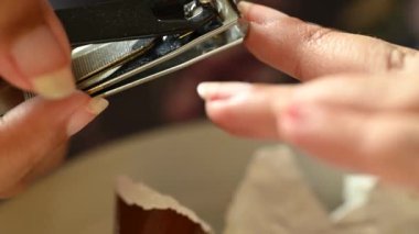 Tırnak kesen güzel bir kadın modelin yakın çekimi. 4K kişisel bakım tırnak şekillendirme görüntüsü. Yaşam tarzında refah. 