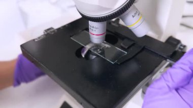 Kadın araştırmacı bilim adamı mikroskop altında örneklere bakıyor. Modern Laboratuvarda Teknolojik Ekipmanlarla çalışan 4K Mikrobiyolog. Biyokimya, ilaç..