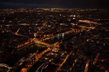 High Resolution Panorama Of Paris Skyline from Eiffel Tower during rainy sunset. Night time light from the city roads and buildings.