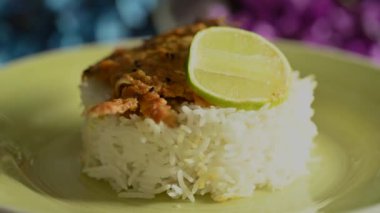 Tahta bir masada sarı bir tabakta servis edilen balık, pirinç ve limon dilimleri ile süslenmiş güzel bir yemek tabağı. Öğle ve akşam yemeği için Hint yemeği..