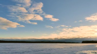 Güneşli bir günde donmuş gölün üzerinde dramatik bulut patlaması. Gün batımında destansı bulut hareketi. Zaman Ayarı 4K videosu. 