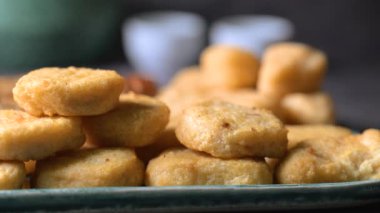 Kızarmış tavuk kanadı, tavuk nugget ve bir tabakta biftek kebabı. Kebap bir ketçap kasesine batırıldı. Masa üzerinde siyah bir arka plan 4K 'da bir Macro shot..