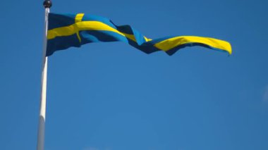 Ulusal gün kutlamaları ve Avrupa Birliği 'nin sembolü için mavi gökyüzünün altında dalgalanan İsveç bayrakları. İsveç Ulusal Günü, yaz ortası, telif alanı.