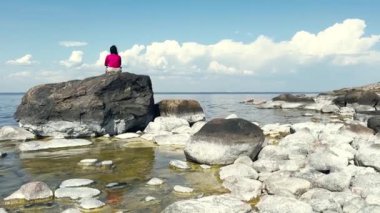 Deniz kıyısında meditasyon yapan mutlu genç bir kadın. Kadınlar gün doğumunda deniz fenerinde yoga yapıyorlar. Kopya uzay deniz arka planına sahip huzur manzarası. 