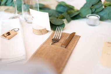 Düğün dekoru. Güzel bir etkinlik mekanı. İçinde çiçekler ve sandalyeler olan kapalı bir resepsiyon masası. Çiçeklerin ve bitkilerin ahşap tezgahlardaki kompozisyonları.