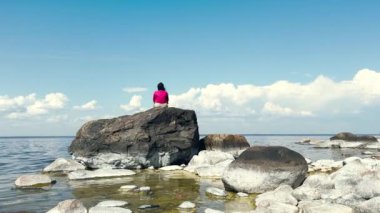Mutlu Asyalı kadın deniz kıyısında meditasyon yapıyor. Kadınlar gün doğumunda deniz fenerinde yoga yapıyorlar. Kopya uzay deniz arka planına sahip huzur manzarası. 