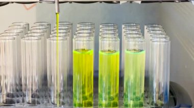 Yeşil floresan bileşiği otomatikleştirilmiş makinede ayrılır. Sütun kromatografisinin test tüpü fraksiyon toplama tekniği. Eğitim ve sanayi konsepti.