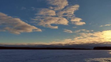 Donmuş gölün üzerinde güneşli bir günde gerçek zamanlı dramatik bulut. Gün batımında destansı bulut hareketi. Zaman Ayarı 4K videosu. 