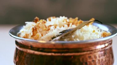 Güzel dekore edilmiş biryani ve pirinç kasesinde servis edilen limon dilimleriyle kızartılmış pirinç. Öğle ve akşam yemeği için Hint yemeği..