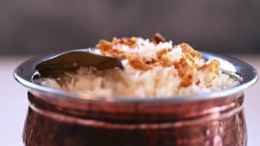 Güzel dekore edilmiş biryani ve pirinç kasesinde servis edilen limon dilimleriyle kızartılmış pirinç. Öğle ve akşam yemeği için Hint yemeği..