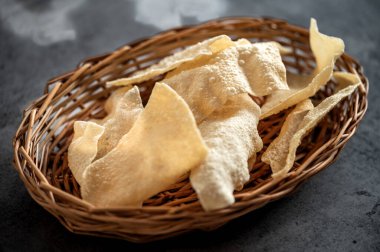 Kavrulmuş papad, Hint geleneksel başlangıç yemeği veya garnitür olarak domates ketçapıyla renkli ya da ahşap masa üstü servis edilir..