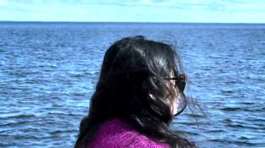 Deniz kıyısında dinlenen Asyalı bir kadın. Huzur anlarında bulunan ruh sağlığı ve kendine güvenin ilham kaynağı. Kadınlar boş vakitlerini doğada geçirirler.. 