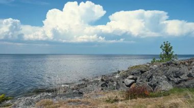4K Majestic güneşli deniz ufkuyla manzara. İnanılmaz bir deniz feneri ve gökyüzü bulutları. Renkli beyaz bulutlar Doğa çevre arkaplanı.