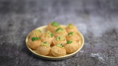 Baharatlı suyla kaplı bir bardakta Hint sokak yemeği fuşkası yakın. Pani puri Hindistan 'da bir sohbet konusu. 4K Hint sokak yemekleri.