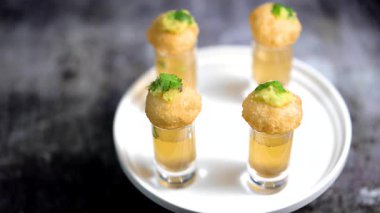 Baharatlı suyla kaplı bir bardakta Hint sokak yemeği fuşkası yakın. Pani puri Hindistan 'da bir sohbet konusu. 4K Hint sokak yemekleri.
