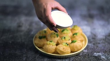 Baharatlı suyla kaplı bir bardakta Hint sokak yemeği fuşkası yakın. Pani puri Hindistan 'da bir sohbet konusu. 4K Hint sokak yemekleri.