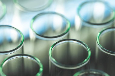 Kadın kimya bilimcisi laboratuarda deneyler yapıyor. Boru hattı tüplere renkli solüsyon ekliyor, tıbbi soyut arkaplan.