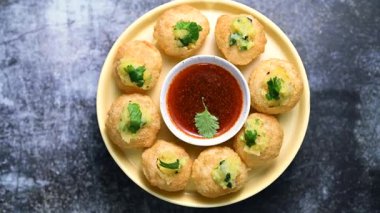 Baharatlı suyla kaplı bir bardakta Hint sokak yemeği fuşkası yakın. Pani puri Hindistan 'da bir sohbet konusu. 4K Hint sokak yemekleri.