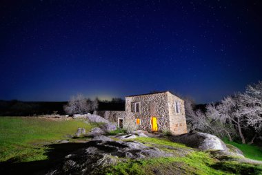 Old building that served as a mill illuminated at night clipart