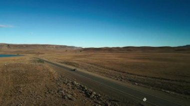 Patagonya 'da araba sürüşünün hava görüntüsü, arka planda kuru bozkır manzarası. Yüksek kalite 4k görüntü