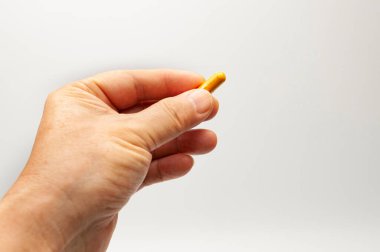 El ele tutuşan zerdeçal takviye kapsülü beyaz arkaplanda kopya alanı ile izole edildi.