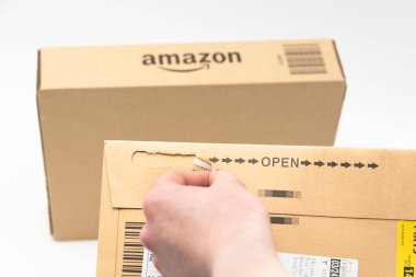 Fuji Şehri, Shizuoka-Ken, Japonya - 26 Mart 2023: Arka planda biraz bulanık Amazon logosu olan karton kutulu elden teslim zarfı. Beyaz arkaplanda izole.