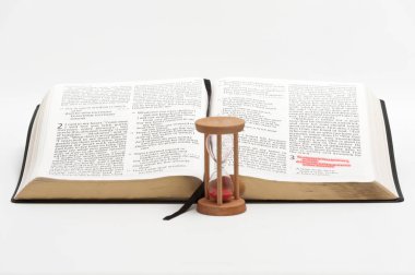 Kum Saati ve Kutsal Kitap 'ın kırmızı ile işaretlenmiş 3. bölümün 1. ayetine özel olarak odaklanmış hali. Beyaz arkaplanda izole.