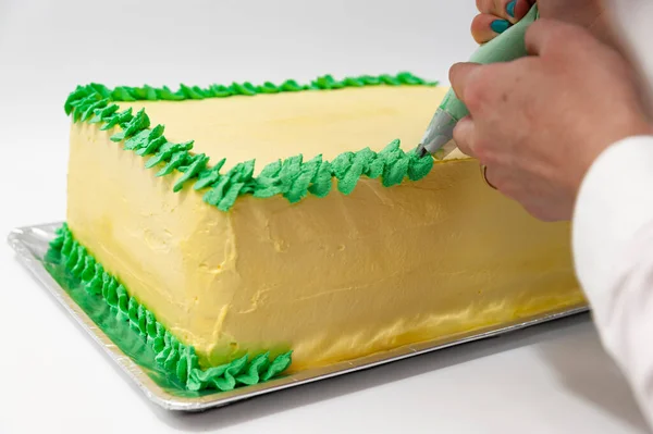 Женщина Украшает Зеленый Желтый Праздничный Торт Кондитерской Сумкой Крупным Планом — стоковое фото