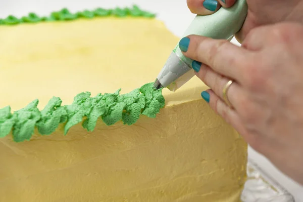 Mujer Decorando Pastel Cumpleaños Verde Amarillo Con Bolsa Pastelería Cerca —  Fotos de Stock