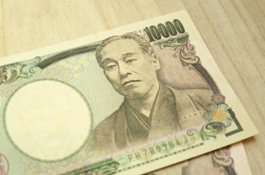 10 bin yen (10 bin yen) banknotlar istiflendi. Japon parası. Kağıt para. Tahta masada izole edilmiş. Üst görünüm.