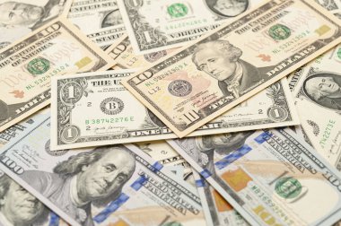 1, 10, 50 ve 100 dolarlık banknotların etrafa saçıldığı zenginlik ve refah görüntüsü.