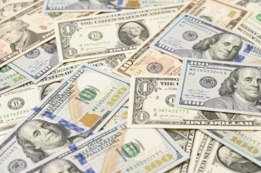1, 10, 50 ve 100 dolarlık banknotların etrafa saçıldığı zenginlik ve refah görüntüsü.