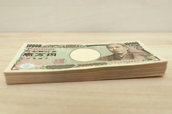 1万円 10万円 の紙幣が積み重なっている 日本のお金 紙幣について 木のテーブルで隔離される サイドビュー — ストック写真
