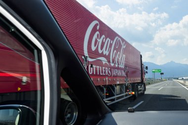 Komono-shi, Mie Prefecture, Japan - October 25, 2023: Red delivery truck of Coca-Cola Bottlers Japan Inc. on Shin-Tomei Highway. clipart