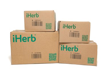 Fuji-shi, Shizuoka-ken, Japonya - 28 Eylül 2024: iHerb, çevrimiçi destek ve vitamin deposu - beyaz arka planda izole edilmiş karton paketleme kutuları.