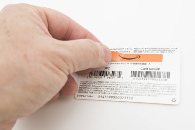 Fuji-shi, Shizuoka-ken, Japonya - 14 Kasım 2024 - El, beyaz arka planda izole edilmiş Amazon hediye kartından kurcalamaya dayanıklı mührü kaldırıyor.