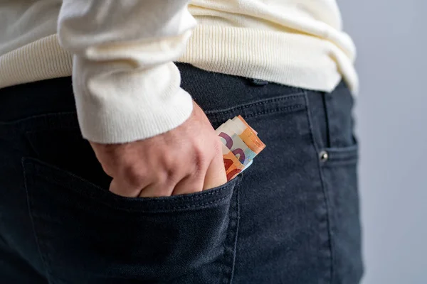 黒いパンツのポケットに別のユーロ紙幣を持っている男 — ストック写真