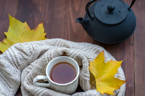 木製のテーブルの上に秋のカラフルな葉に囲まれた黒鉄アジア茶 — ストック写真