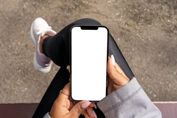 非洲妇女手持带有白色空白屏幕的电话进行模仿和演示的特写照片 图库照片