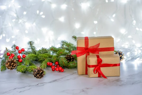 两个礼品盒 内附红色缎带 衬托着圣诞彩灯的背景 图库图片