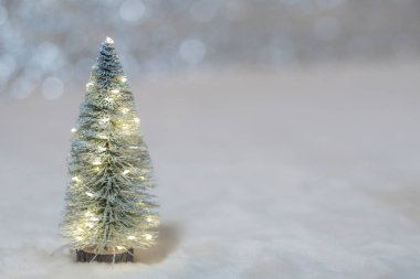 Işıklı karlı Noel ağacı oyuncağı ve uzay kopyası olan ışıkların soyut bokeh arkaplanı