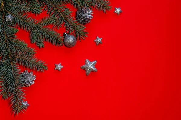Έλατο Κλαδιά Ασημένια Κουκουνάρια Και Άλλα Χριστουγεννιάτικα Στολίδια Κόκκινο Φόντο — Φωτογραφία Αρχείου