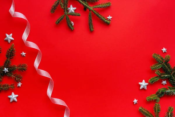 Vánoční Plochý Rám Jedlových Větví Červeném Pozadí Zdobené Stříbrnými Hvězdami — Stock fotografie