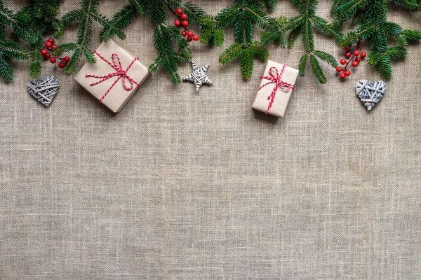 スプルースの枝 ギフトボックスや装飾品で作られたフラットクリスマスフレーム バラップの背景にあります クリスマスのコンセプト コピースペース付きのトップビュー — ストック写真